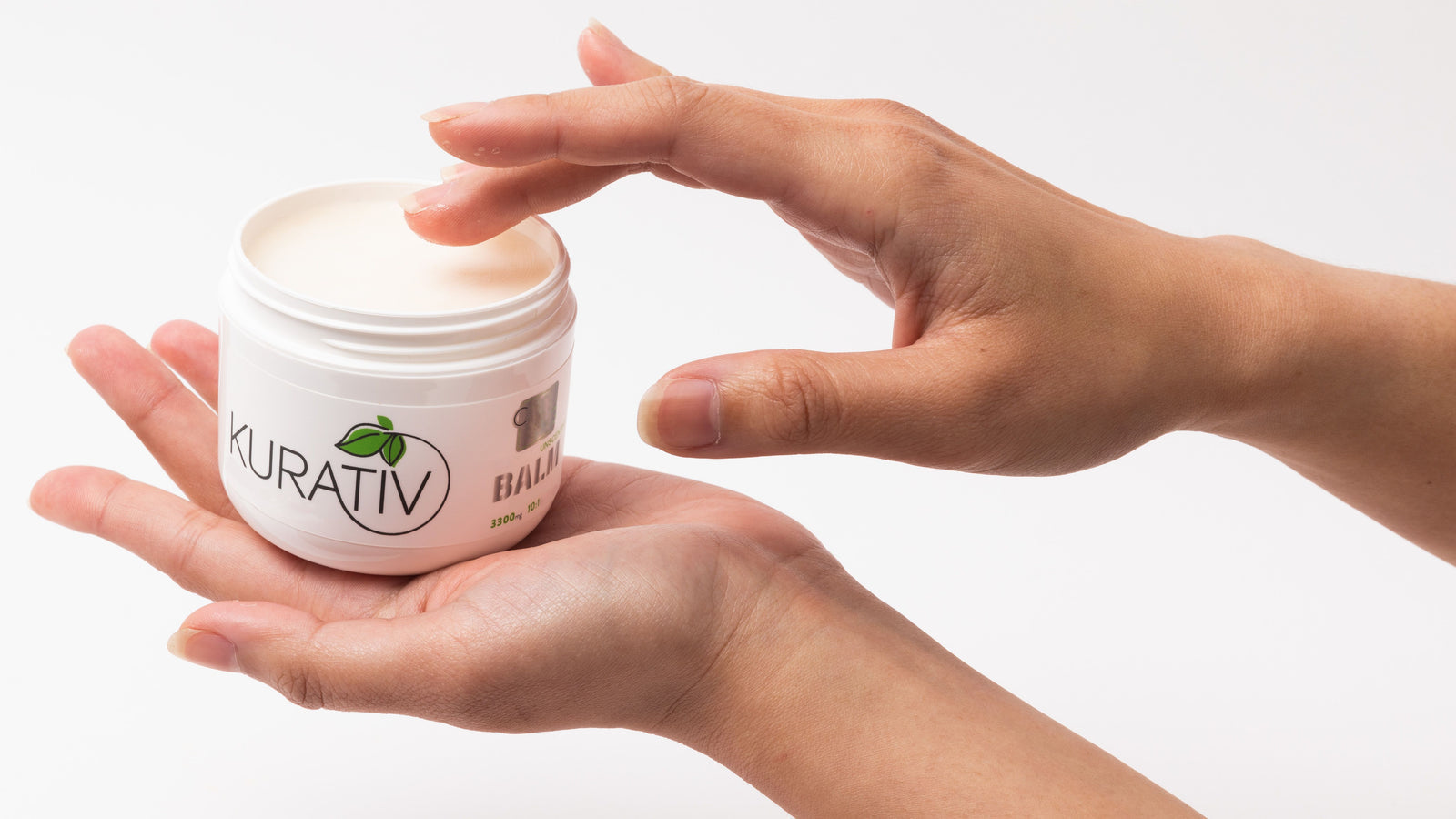Hands massaging Kurativ CBD topical balm into skin as part of a recovery routine