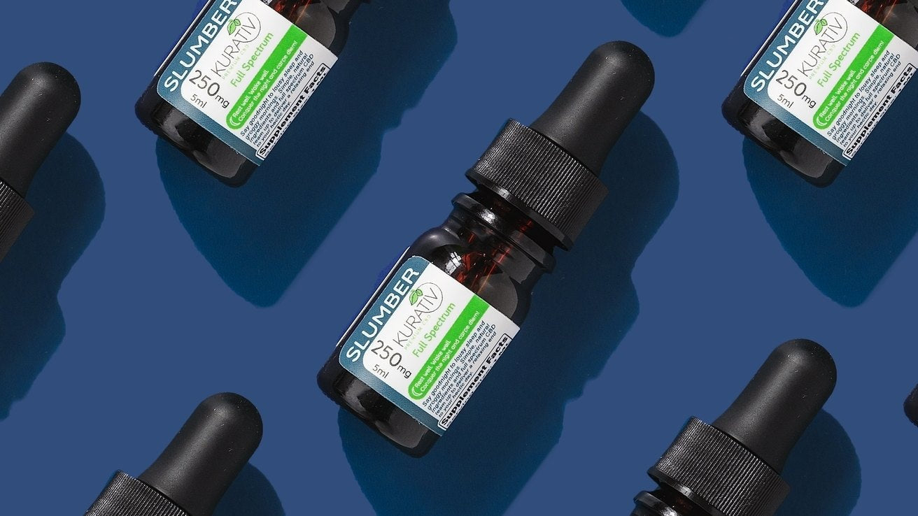 Kurativ CBD full spectrum, broad spectrum, and THC-free oil bottles arranged together in moody lighting